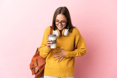 Soyutlanmış pembe arka planda genç bir bayan çok gülüyor.