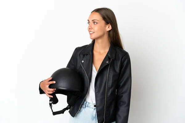 Woman with a motorcycle helmet over isolated white background looking side