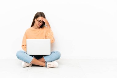 Yerde oturan dizüstü bilgisayarı yla gülen genç kadın