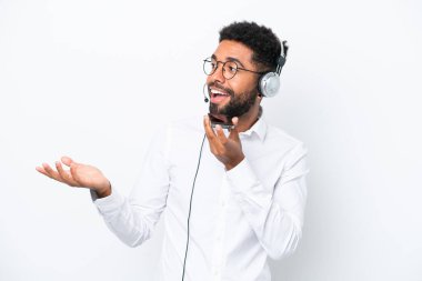 Tele pazarlamacı Brezilyalı adam beyaz arka planda izole edilmiş bir kulaklıkla çalışıyor cep telefonuyla sohbet ediyor.