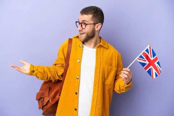 Mladý Běloch Drží Vlajku Spojeného Království Izolované Fialovém Pozadí Překvapivým — Stock fotografie