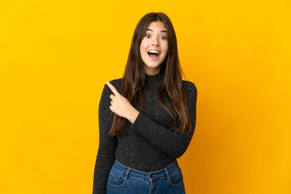 Adolescente Menina Brasileira Isolada Fundo Amarelo Surpreendido Apontando Lado — Fotografia de Stock