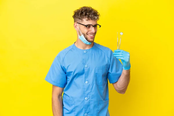 Dentist Blonde Man Holding Tools Isolated Background Looking Side Smiling — Fotografia de Stock