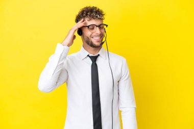 Telemarketer blonde man working with a headset isolated on yellow background has realized something and intending the solution