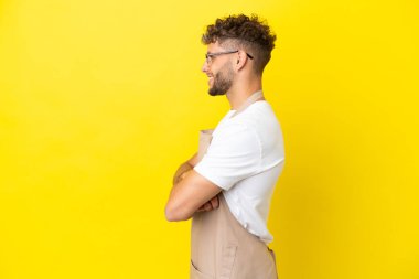 Restoran garsonu. Sarışın adam, sarı arka planda yalıtılmış.