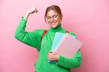 Pembe arka planda izole edilmiş beyaz bir kadın güçlü bir jest yapıyor.