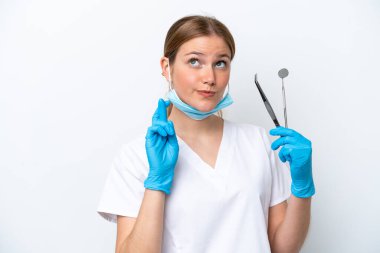 Beyaz arka planda izole edilmiş aletleri tutan beyaz dişçi kadın, şans diliyor ve en iyisini diliyor.