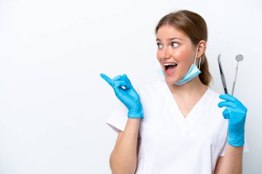 Beyaz arka planda izole edilmiş aletleri tutan beyaz dişçi kadın çözümü fark etmek için parmağını kaldırıyor.