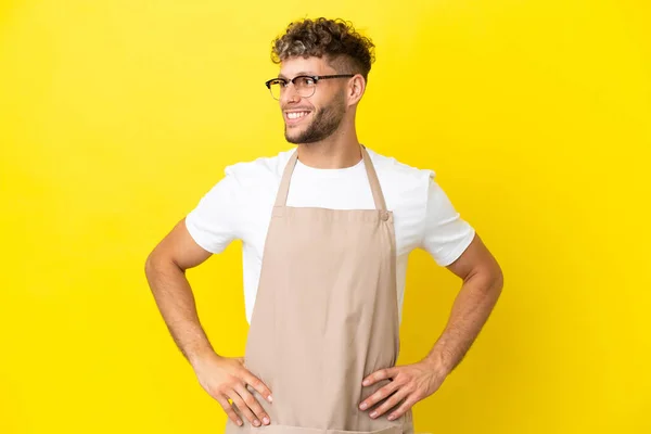 Restaurant Waiter Blonde Man Isolated Yellow Background Posing Arms Hip — Zdjęcie stockowe