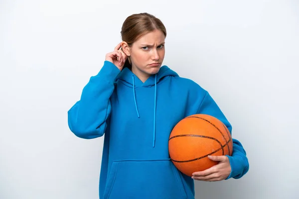 年轻的高加索女子在白人背景下打篮球时感到疑惑 — 图库照片