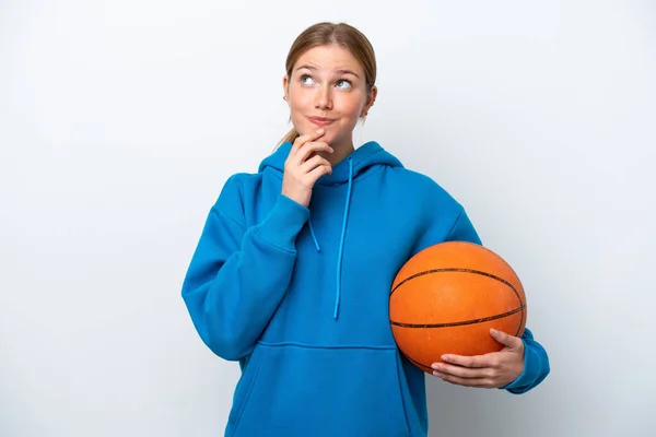 年轻的高加索女子在白人背景下孤零零地打篮球 面带微笑抬起头来看 — 图库照片