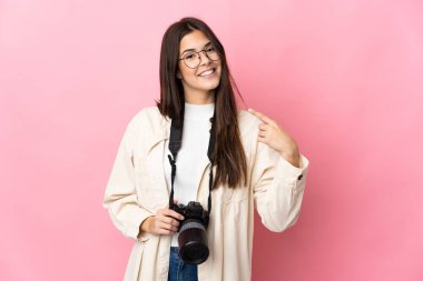 Genç fotoğrafçı Brezilyalı kız pembe arka planda izole edilmiş bir şekilde baş parmak hareketi yapıyor.