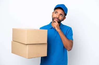 Teslimatçı Brezilyalı adam beyaz arka planda izole edilmiş ve yukarı bakıyor.