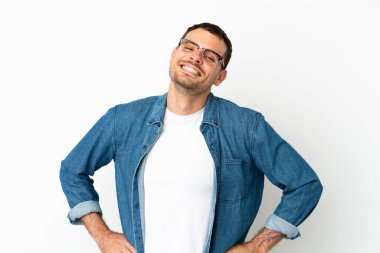 Brezilya 'lı erkek izole edilmiş beyaz arka planda kolları kalçasında ve gülümsüyor.