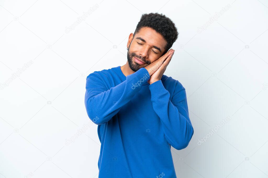 Young Brazilian man isolated on white background making sleep gesture in dorable expression