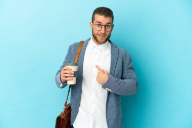 Kafkasyalı genç işadamı, mavi arka planda yalıtılmış ve şaşırmış bir yüz ifadesi var.