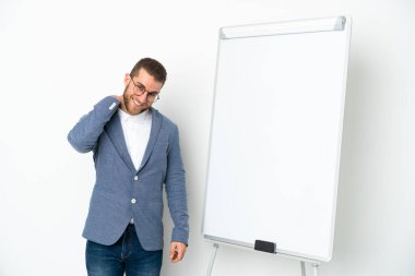 Beyaz arka planda izole edilmiş beyaz panoda sunum yapan genç iş kadını gülüyor.