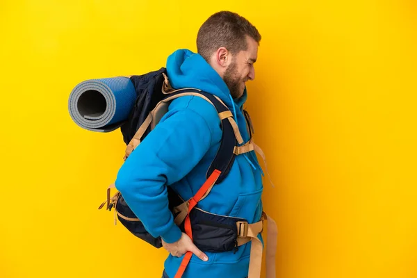 Young Caucasian Mountaineer Man Big Backpack Isolated Yellow Background Suffering — Stockfoto