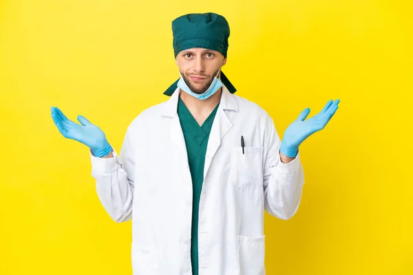 Χειρούργος Ξανθός Άνδρας Πράσινη Στολή Απομονωμένος Κίτρινο Φόντο Έχοντας Αμφιβολίες — Φωτογραφία Αρχείου