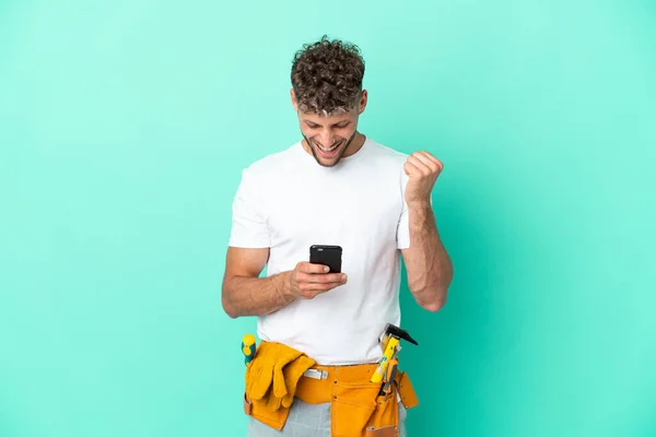 Young Electrician Blonde Man Isolated Green Background Surprised Sending Message — Stok fotoğraf