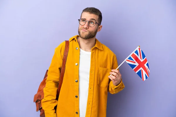 Mladý Běloch Drží Vlajku Spojeného Království Izolovanou Fialovém Pozadí Dívá — Stock fotografie