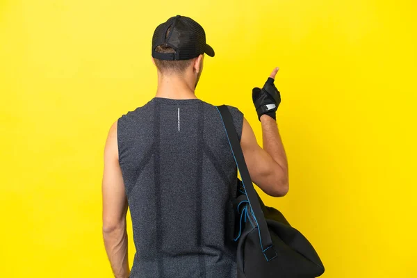 Young Sport Blonde Man Sport Bag Isolated Yellow Background Pointing — Foto Stock