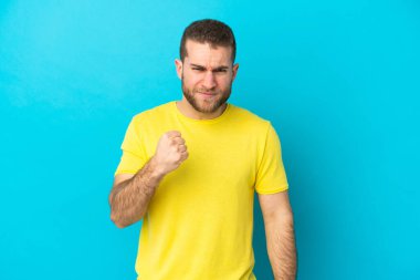 Mutsuz bir ifadeyle mavi arka planda izole edilmiş yakışıklı beyaz bir adam.