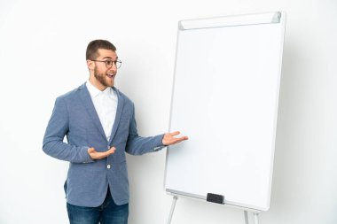 Beyaz arka planda beyaz panoda sunum yapan genç bir iş kadını sürpriz bir ifadeyle yan tarafa bakıyor.