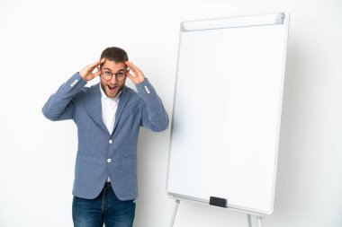 Young business woman giving a presentation on white board isolated on white background with surprise expression
