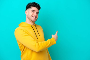 Kafkasyalı genç adam mavi arka planda izole edilmiş.