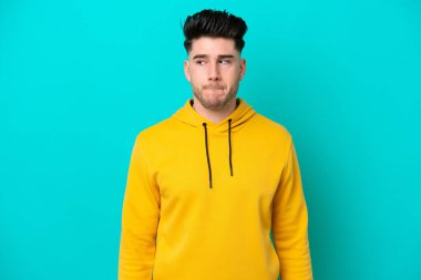 Kafkasyalı genç adam mavi arka planda izole edildi.