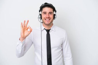 Tele pazarlamacı beyaz arka planda izole edilmiş beyaz adam parmaklarıyla tamam işareti gösteriyor