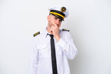 Kafkasyalı uçak pilotu beyaz arka planda izole edilmiş, kuşkuları var ve kafası karışmış bir yüz ifadesi var.