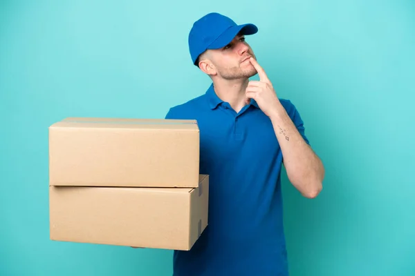 Lieferung Kaukasischen Mann Isoliert Auf Blauem Hintergrund Mit Zweifeln Beim — Stockfoto