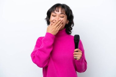 Genç Arjantinli şarkıcı kadın beyaz arka planda izole edilmiş mutlu ve ağzı kapalı gülümsüyor.