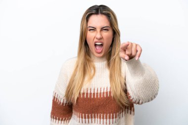 Beyaz arka planda izole edilmiş genç beyaz kadın hayal kırıklığına uğramış ve ön tarafı işaret ediyor.