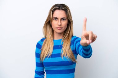 Beyaz arka planda izole edilmiş beyaz tenli genç kadın ciddi bir ifadeye sahip birini sayıyor.