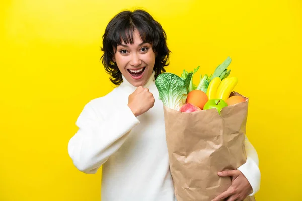 Young Argentinian Woman Holding Grocery Shopping Bag Isolated Yellow Background — Stock Photo, Image