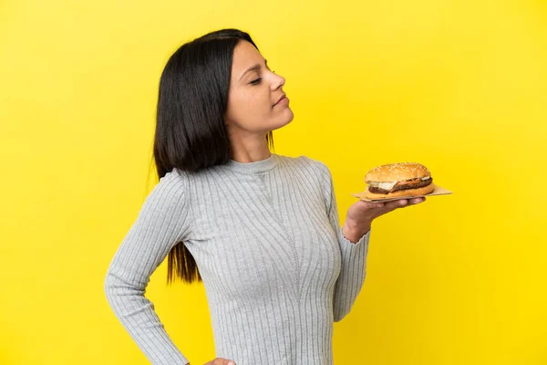 Young Caucasian Woman Holding Burger Isolated Yellow Background Suffering Backache — Stock Photo, Image
