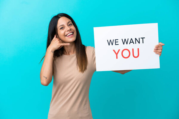 Young woman over isolated background holding We Want You board and making phone gesture