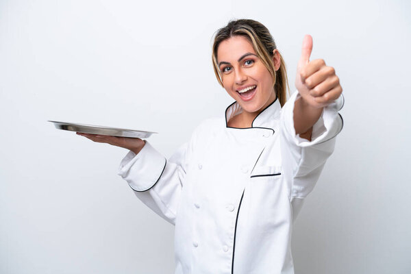 Young chef woman with tray isolated on white background with thumbs up because something good has happened