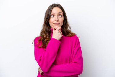 Beyaz arka planda izole edilmiş genç beyaz kadın yukarı bakarken bir fikir düşünüyor.