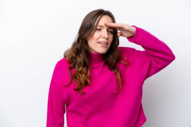 Beyaz arka planda soyutlanmış genç beyaz bir kadın, bir şeye bakmak için uzaklara bakıyor.