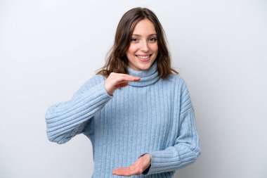 Beyaz arka planda izole edilmiş genç beyaz kadın bir ilan vermek için avucunun içinde hayali bir fotokopi makinesi tutuyor.