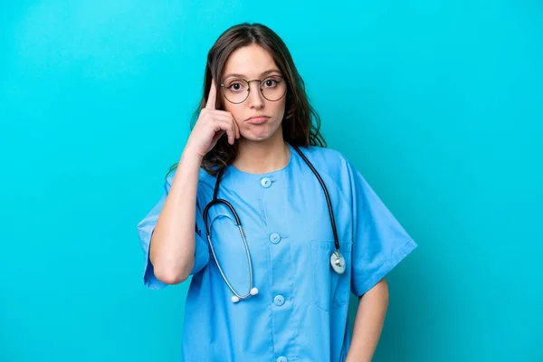 Jonge Chirurg Arts Vrouw Geïsoleerd Blauwe Achtergrond Denken Een Idee — Stockfoto