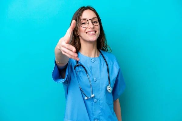 Junge Chirurgin Ärztin Isoliert Auf Blauem Hintergrund Schüttelt Hände Ein — Stockfoto