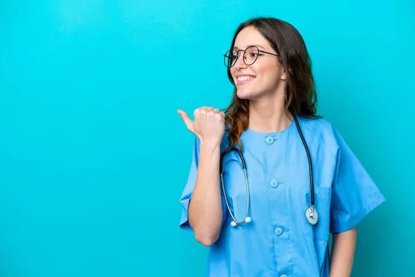 Jonge Chirurg Arts Vrouw Geïsoleerd Blauwe Achtergrond Wijzend Naar Zijkant — Stockfoto
