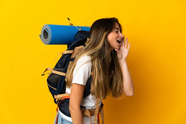Junge Bergsteigerin Mit Einem Großen Rucksack Isoliert Auf Gelbem Hintergrund — Stockfoto