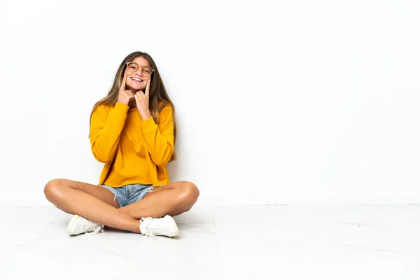 Jeune Femme Assise Sur Sol Isolée Sur Fond Blanc Souriant — Photo