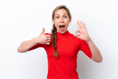 Beyaz arka planda izole edilmiş genç beyaz bir kadın tamam işareti ve baş parmak hareketi gösteriyor.